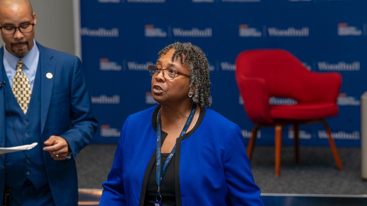 A group of people standing in front of a blue wall

AI-generated content may be incorrect.