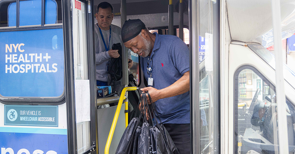Here Andre and Jose Capo (in background), load up on resource bags which are given to community residents who need them. The bags generally include snacks and water, hygiene supplies, fentanyl and xylazine test strips, and Narcan, which Andre and Jose educate patients on how to use. They give away approximately 25 bags daily.