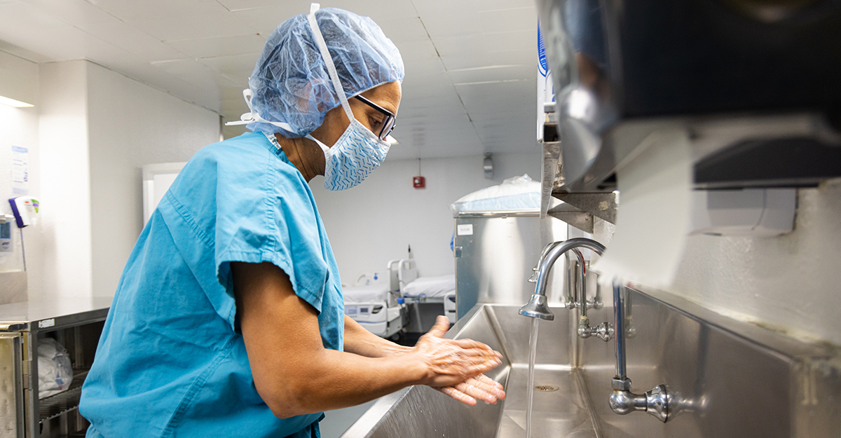 Not a regular hand wash. Dr. McLaurin and the surgical team prep for surgery by completing a prescribed handwashing and donning appropriate personal protective equipment (PPE). (1/3)