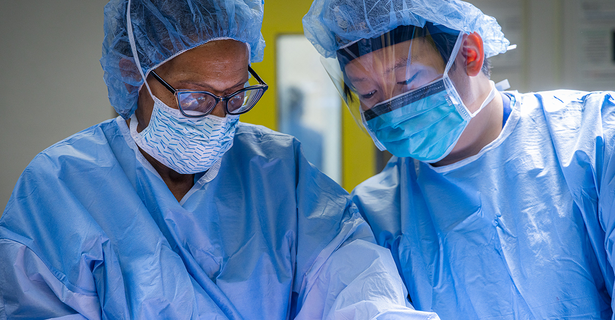 Surgical resident Dr. Jack Zhong attentively observes Dr. McLaurin’s expert hands perform surgery.
