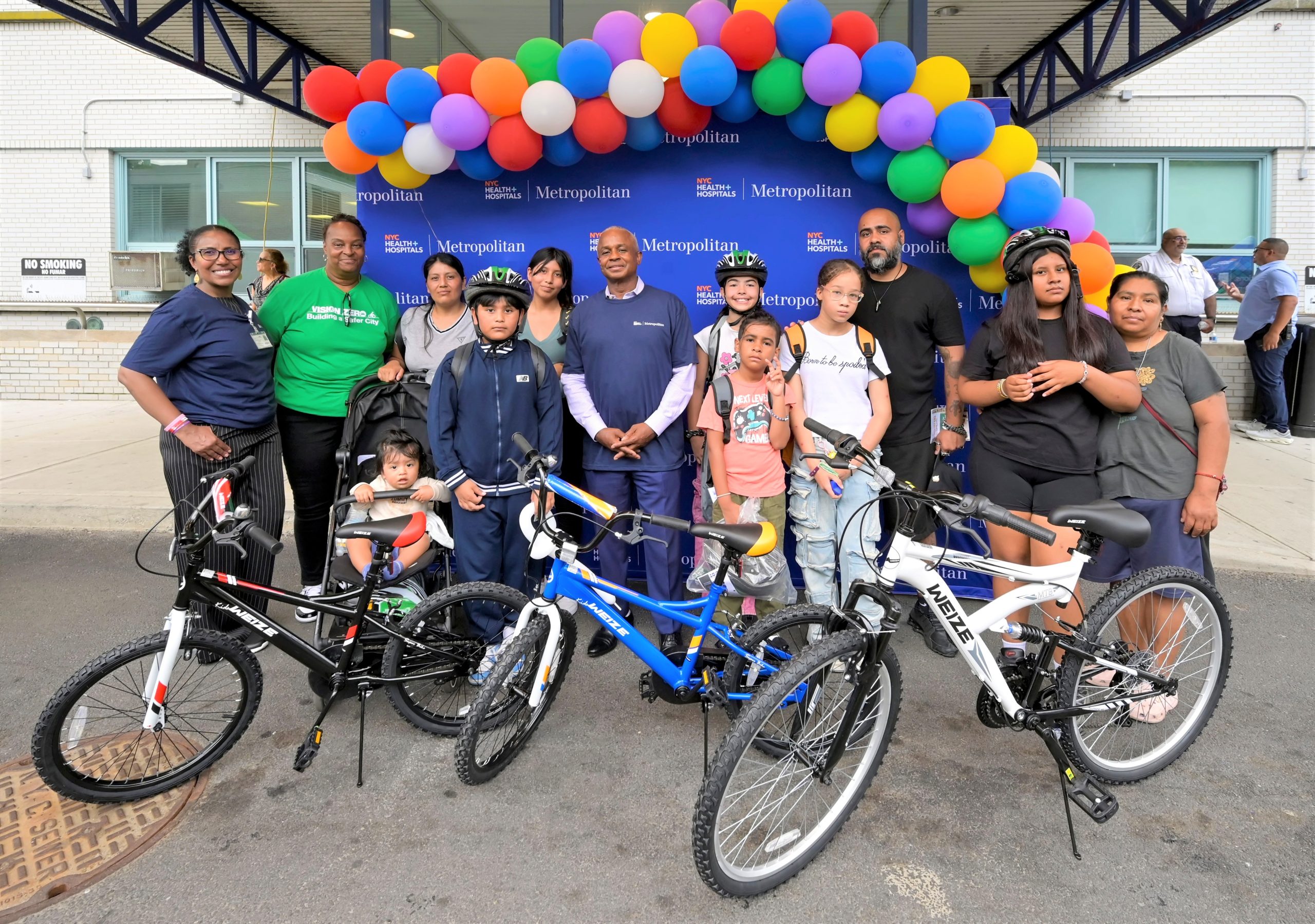 NYC Health + Hospitals/Metropolitan CEO Julian John and COO Elsa Cosme are pictured with the families of children who won bicycles in the raffle at the hospital’s annual Back-to-School Fair.