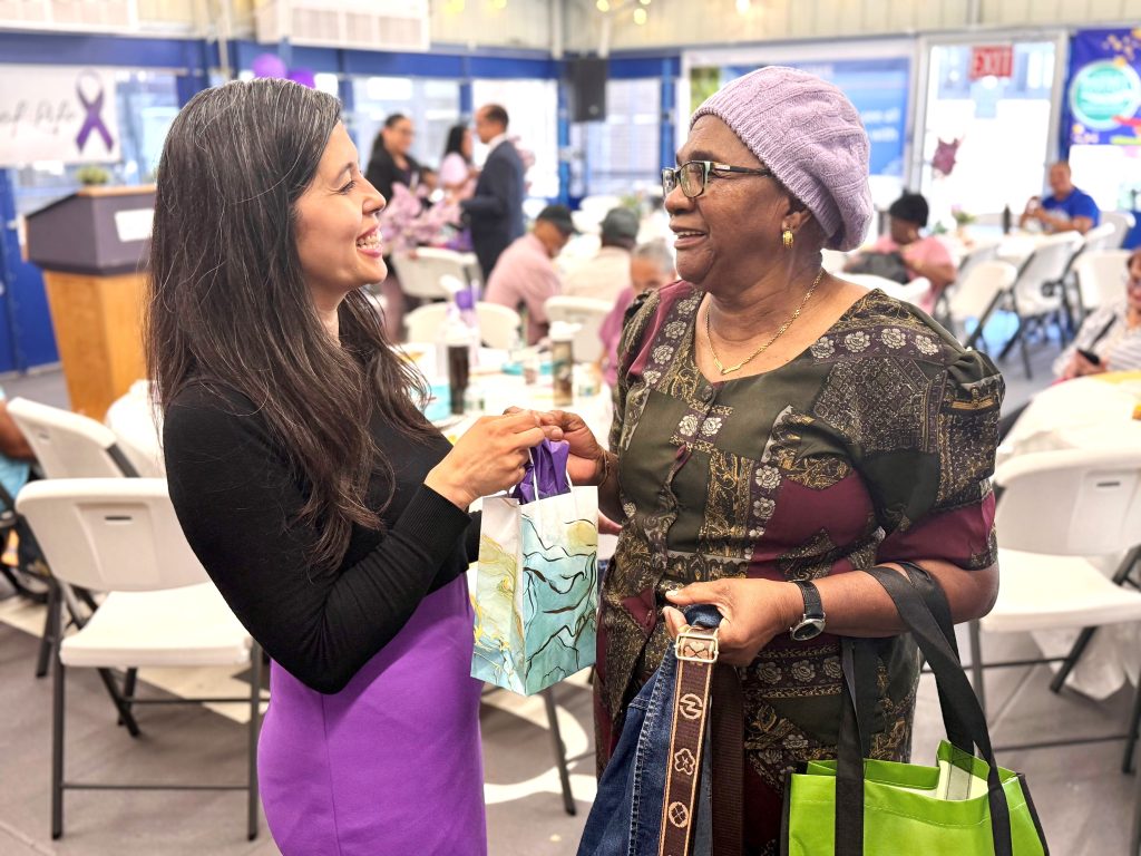 A member of the Queens Cancer Center team presents a gift to a cancer survivor during Queens Hospital’s Celebration of Life event. All cancer survivors in attendance were honored with gifts, and HealthFirst generously sponsored the event, providing free massages to all attendees.