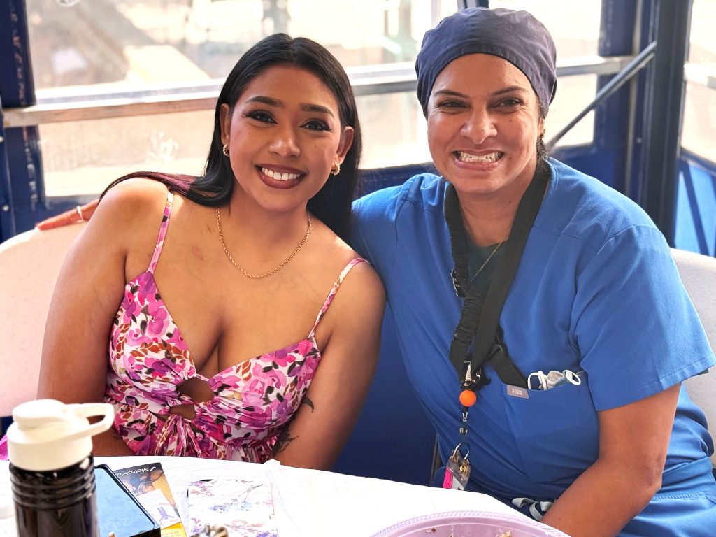 A cancer survivor (left) shares a moment with a dedicated member of the clinical team at the Queens Cancer Center. This heartfelt connection exemplifies the strong bonds formed between staff and survivors, highlighting the unwavering support and commitment of the team in guiding patients through their journeys of resilience and recovery.