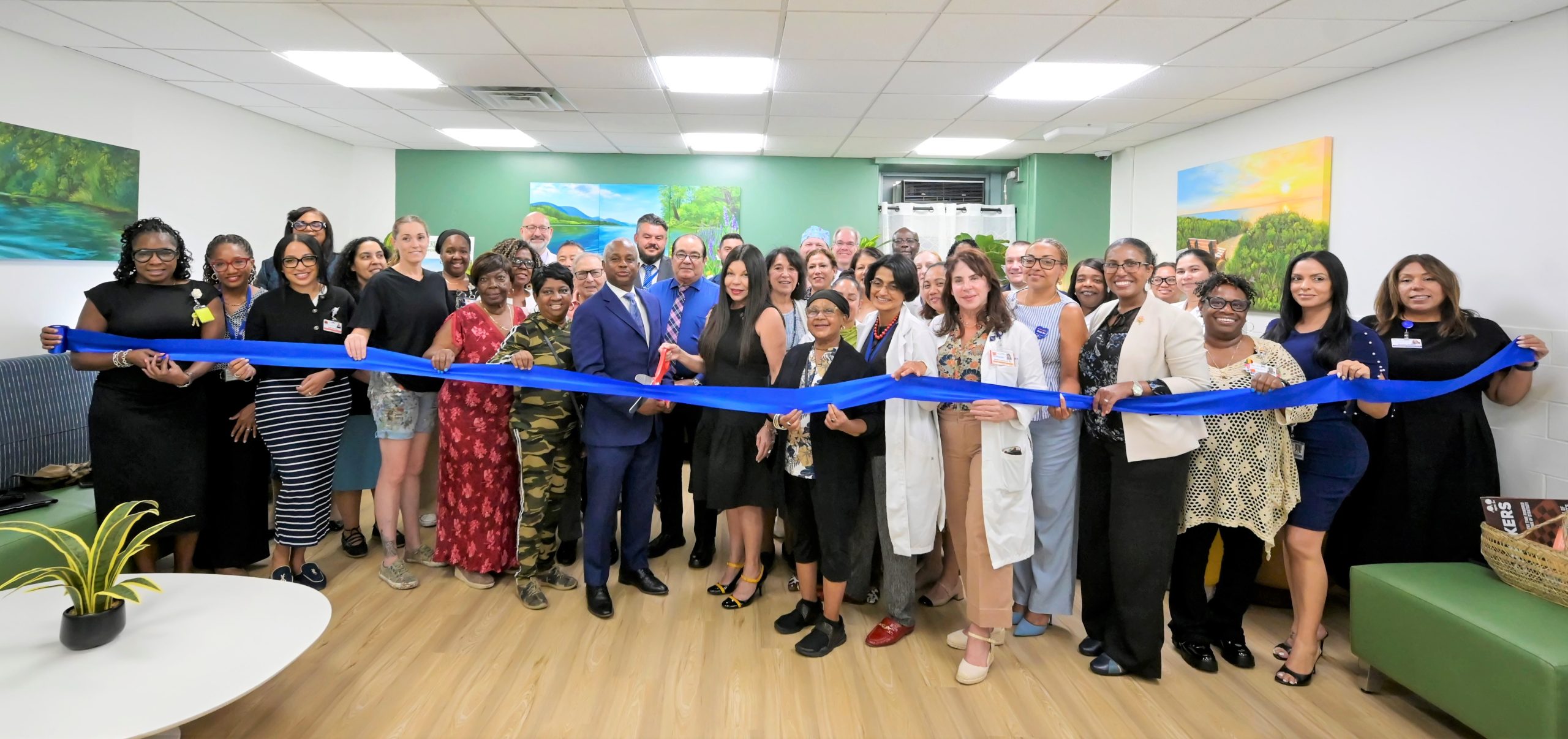 Metropolitan Hospital staff, members of the Patient and Family Advisory Council (PFAC) and Auxiliary, muralist Kristy McCarthy and community members gather for the ribbon cutting ceremony celebrating the new Serenity Room. Photo by Damien Kim.
